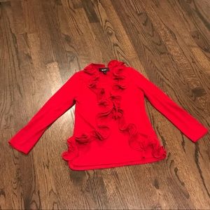 A red shirt with ruffles flowing throughout
